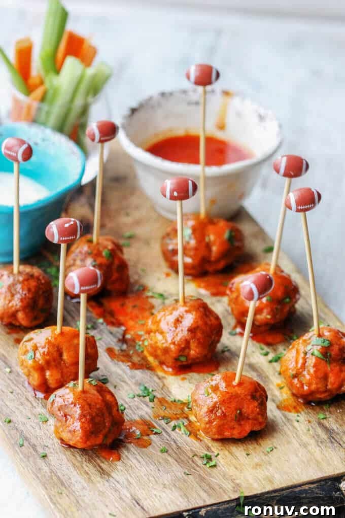 Buffalo Turkey Meatballs are a perfect appetizer for the Big Game. They're also a lighter alternative to a traditional chicken buffalo wings, not only because they have less fat, but also because they're baked, not fried. Not to mention they're also super easy to make. Buffalo Turkey Meatballs with football sticks and hot sauce and blue cheese on a side