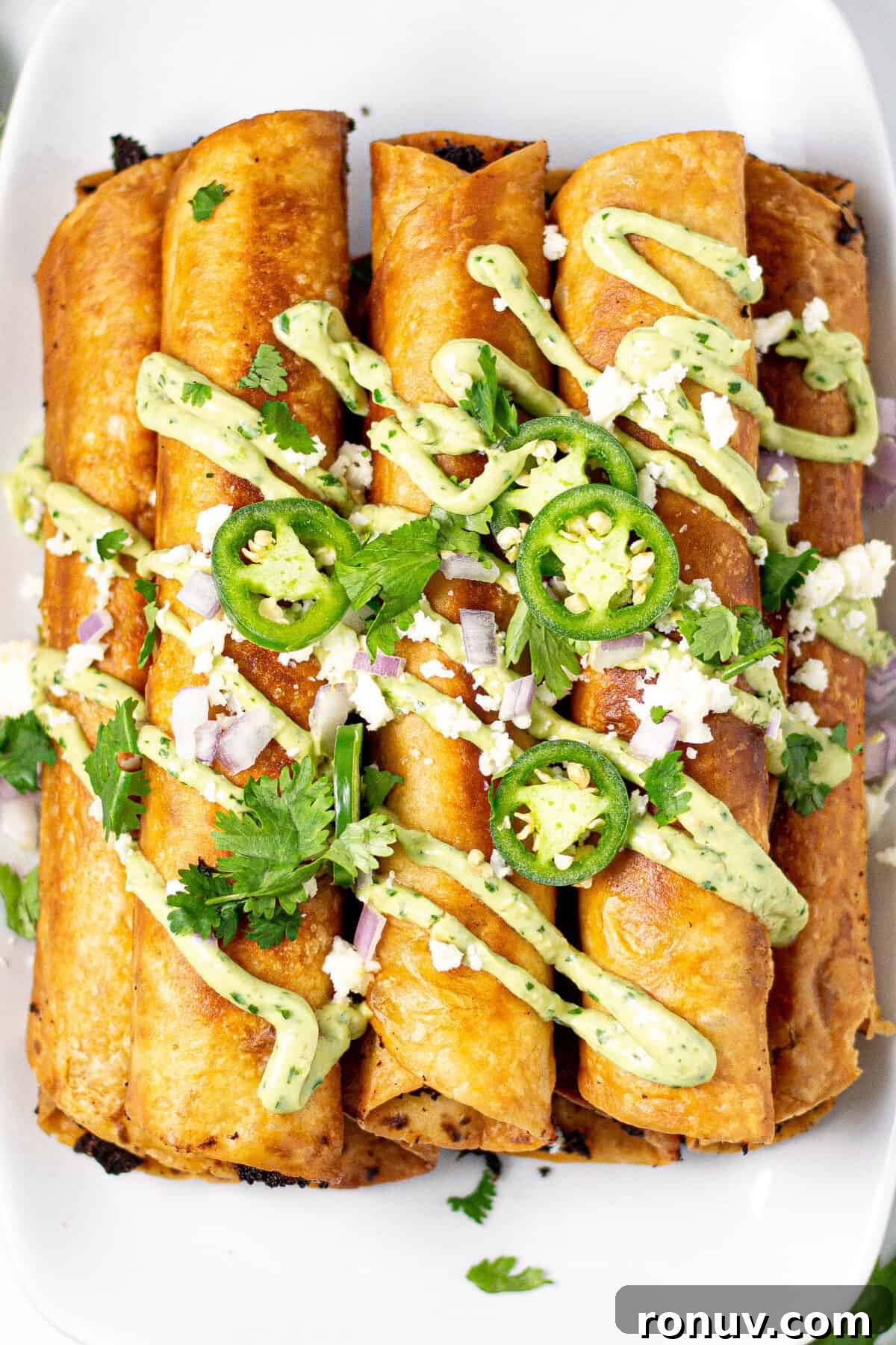 Overhead shot of a platter filled with flautas garnished with cilantro