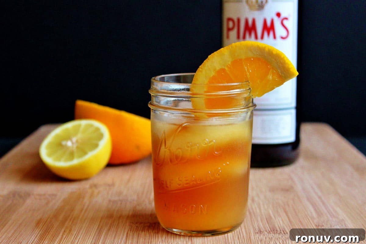 How to Make Pimm's Sundowner Cocktail 6 A glass of Pimm's sundowner cocktail in front of a bottle of Pimm's.