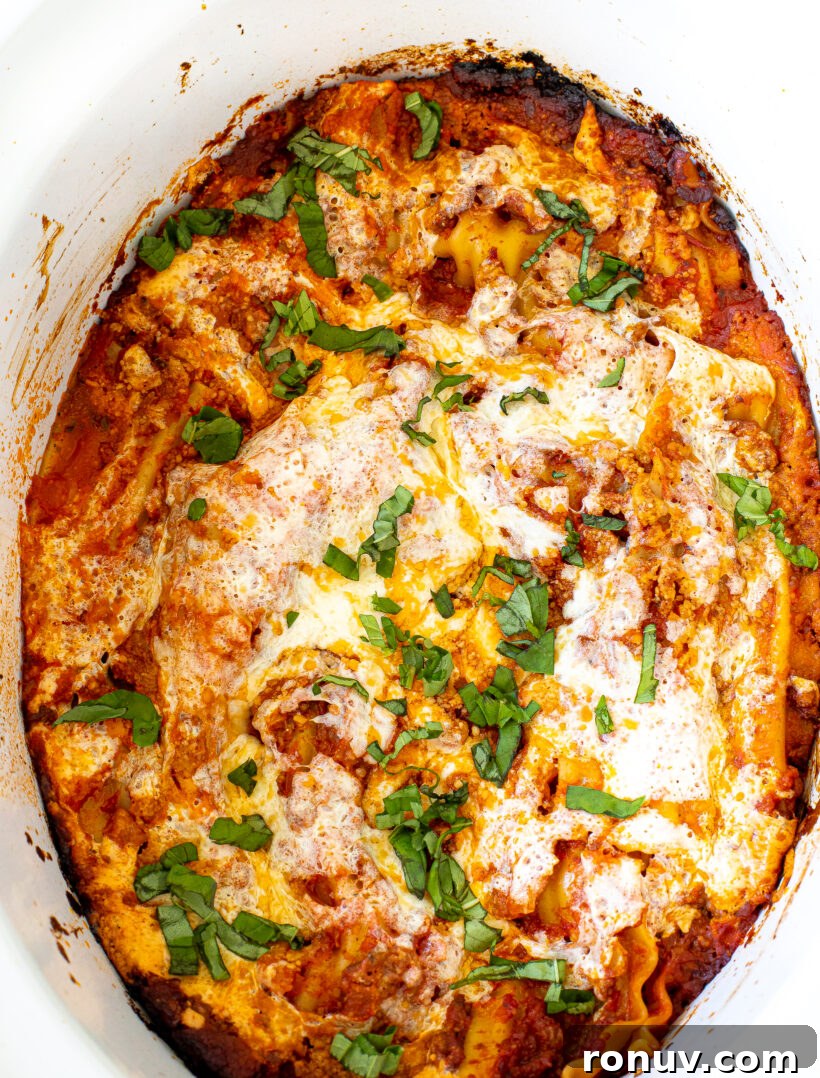 Slow Cooker Lasagna Recipe: Tender, Cheesy Comfort 2 Top down view of slow cooker lasagna in a white crockpot liner.