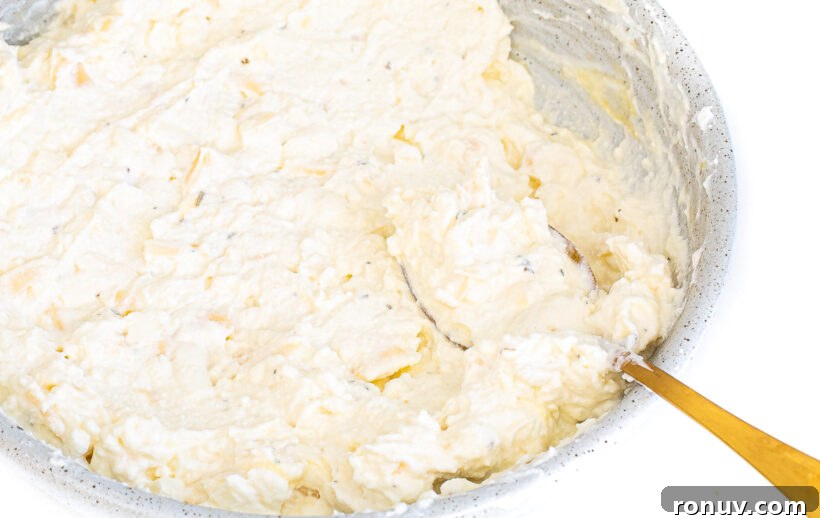 Slow Cooker Lasagna Recipe: Tender, Cheesy Comfort 4 Ricotta filling in a bowl with a gold spoon.