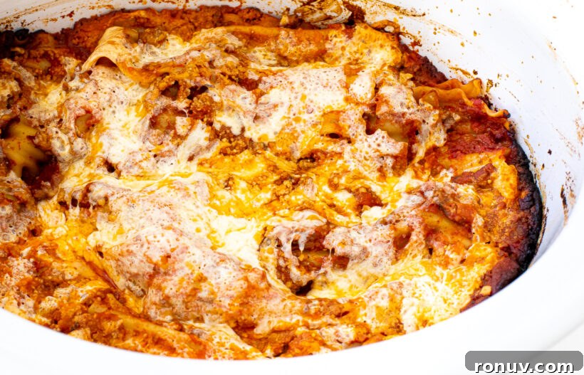 Slow Cooker Lasagna Recipe: Tender, Cheesy Comfort 5 Baked lasagna in a white slow cooker liner.