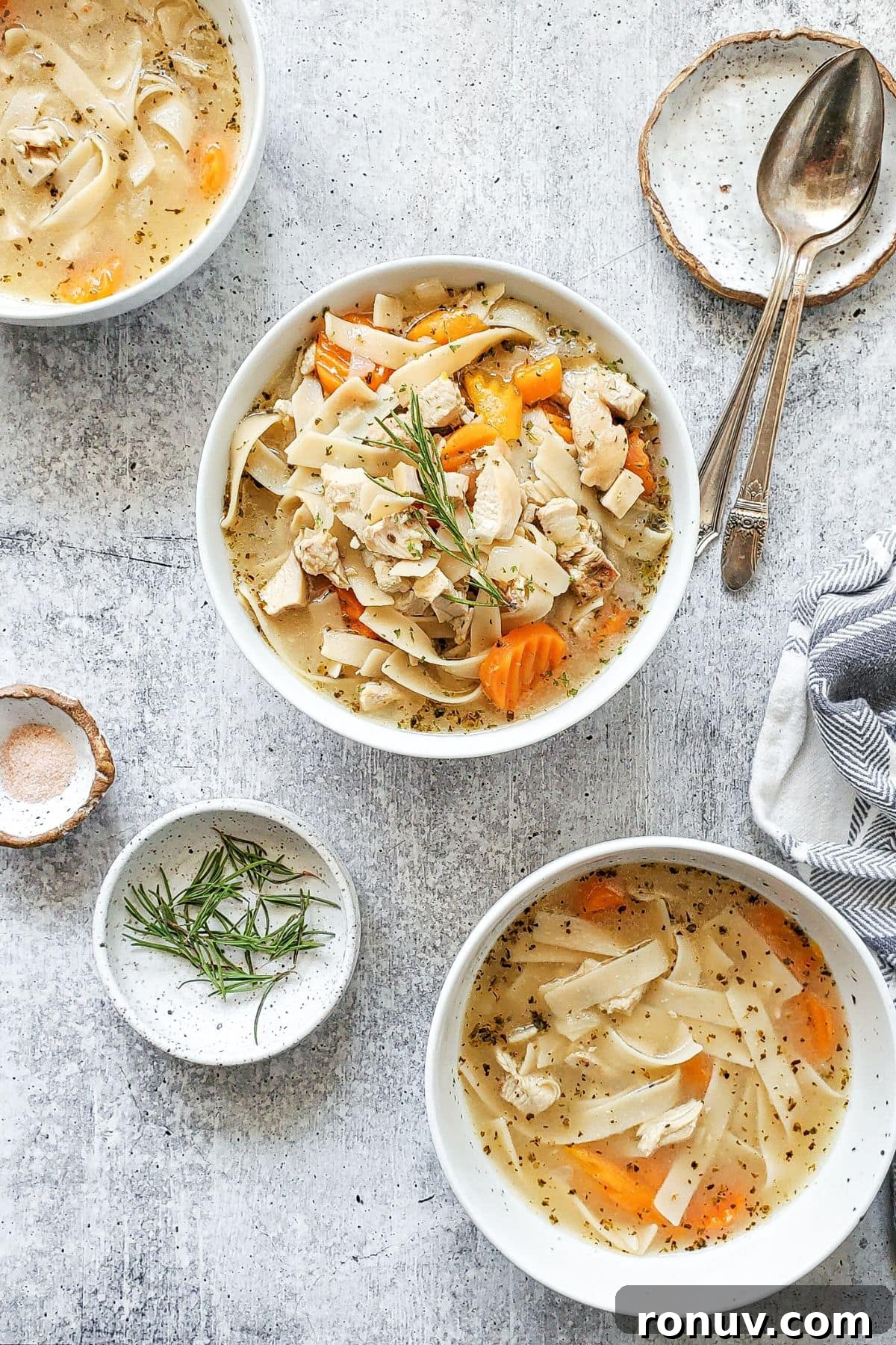 Rotisserie Chicken Noodle Soup Recipe with Herb Broth 2 A big bowl of Rotisserie chicken noodle soup, with 2 smaller bowls filled with soup on the sides.