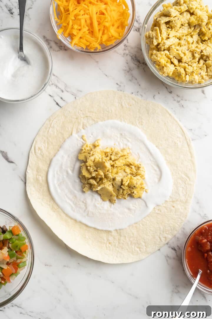 Assembling the burrito Overhead view of tortilla topped with vegan yogurt and vegan scramble