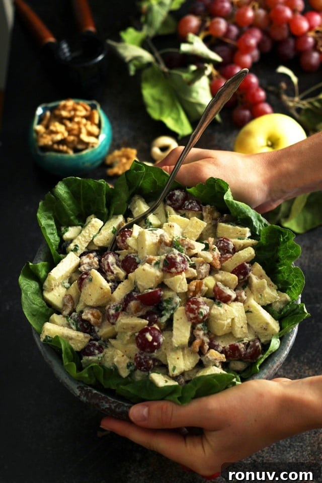 Vegan Waldorf Salad Recipe with Apples, Celery and Walnuts 3 Healthy Vegan Waldorf Salad Recipe - Hands Holding a Bowl above the Table