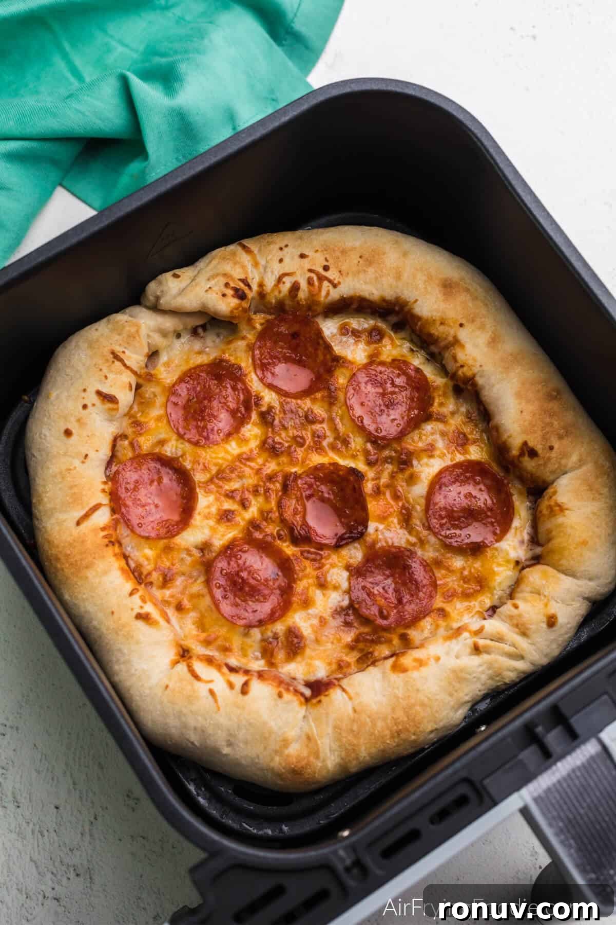 Air fried pizza in the basket of the air fryer. 
