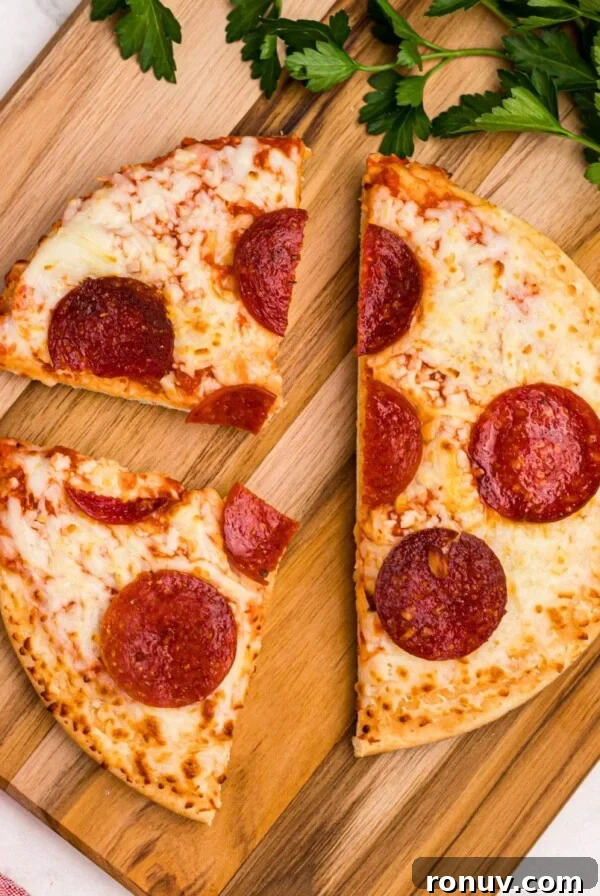 Golden crispy pepperoni pizza on a wooden cutting board
