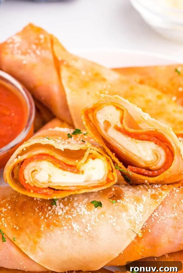 Golden crispy pizza egg rolls stacked on a white plate served with pizza sauce.