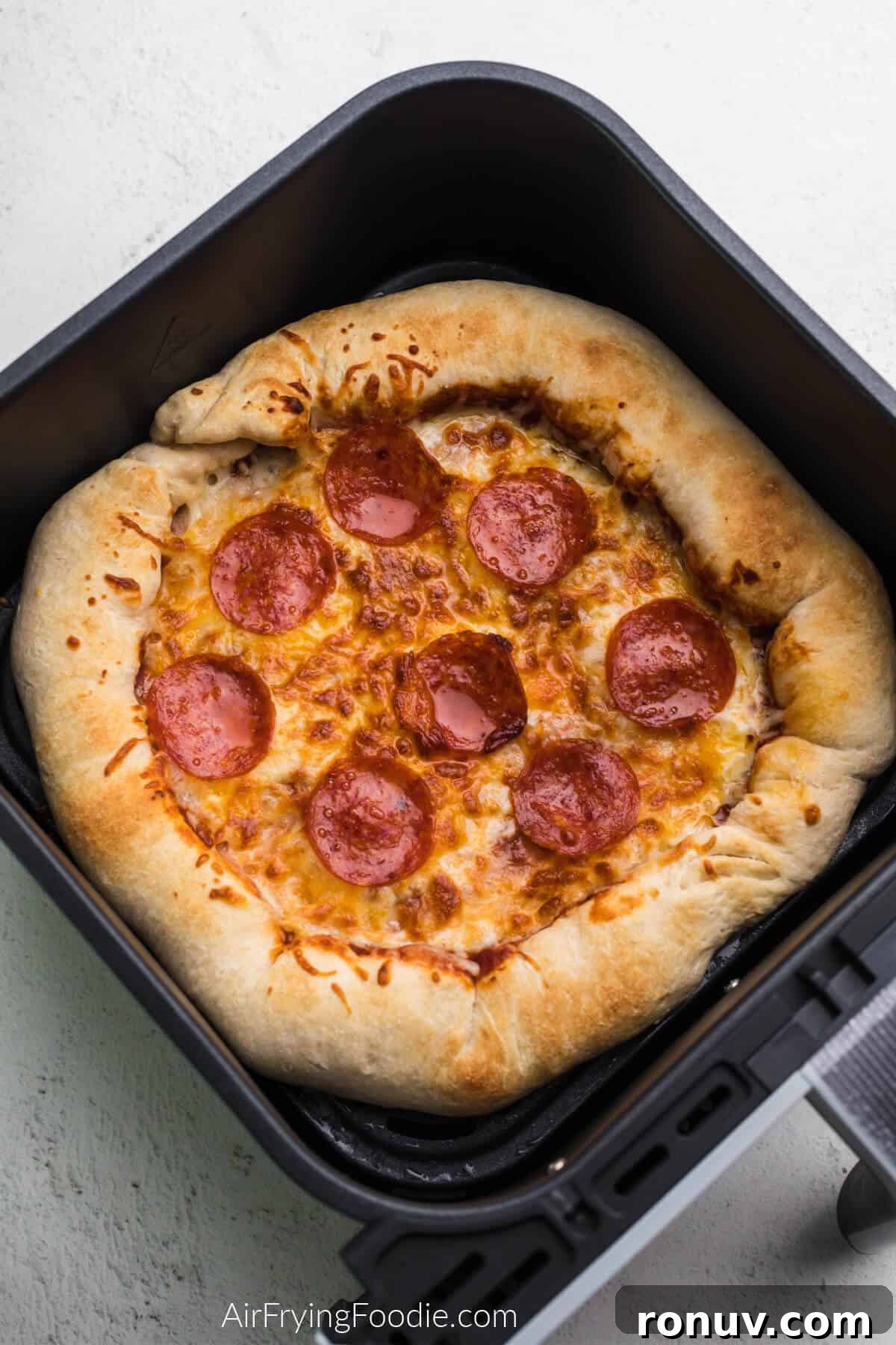Pizza in air fryer basket, ready to serve. 