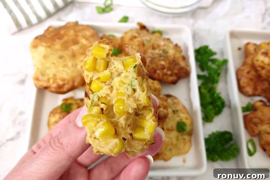Air Fryer Corn Fritters: Crispy Summer Snack Recipe 3 holding up a split in half corn fritter