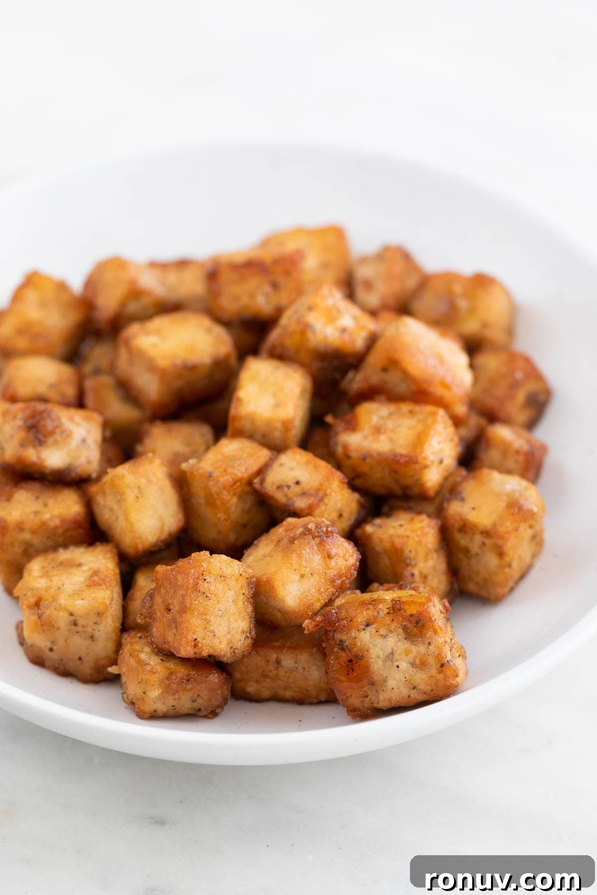 Freeze Tofu for Firmer Texture and Longer Storage 12 Golden brown fried tofu cubes on a plate
