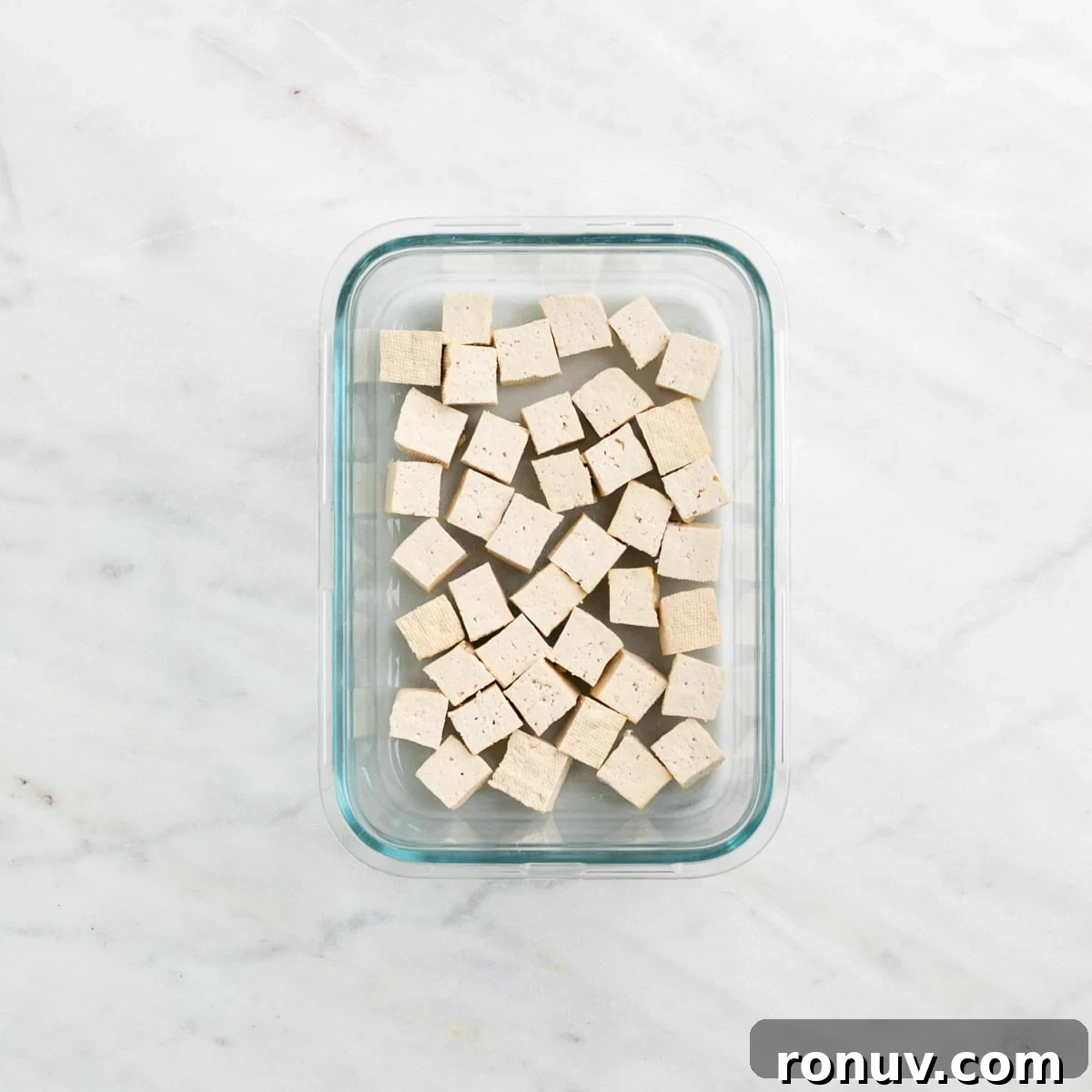 Freeze Tofu for Firmer Texture and Longer Storage 9 Frozen and thawed tofu cubes in a container