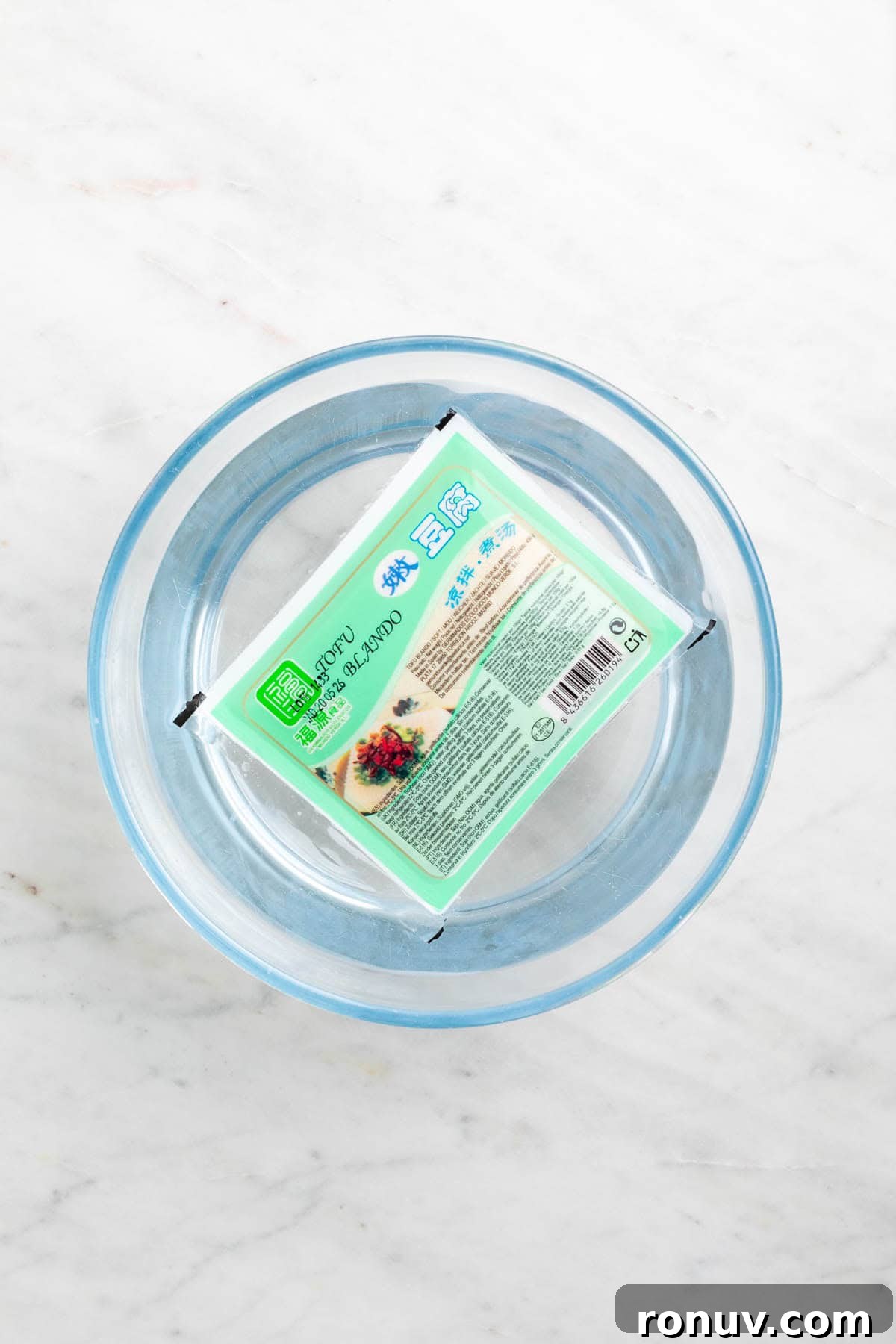 Freeze Tofu for Firmer Texture and Longer Storage 10 Block of frozen tofu thawing in a bowl of water