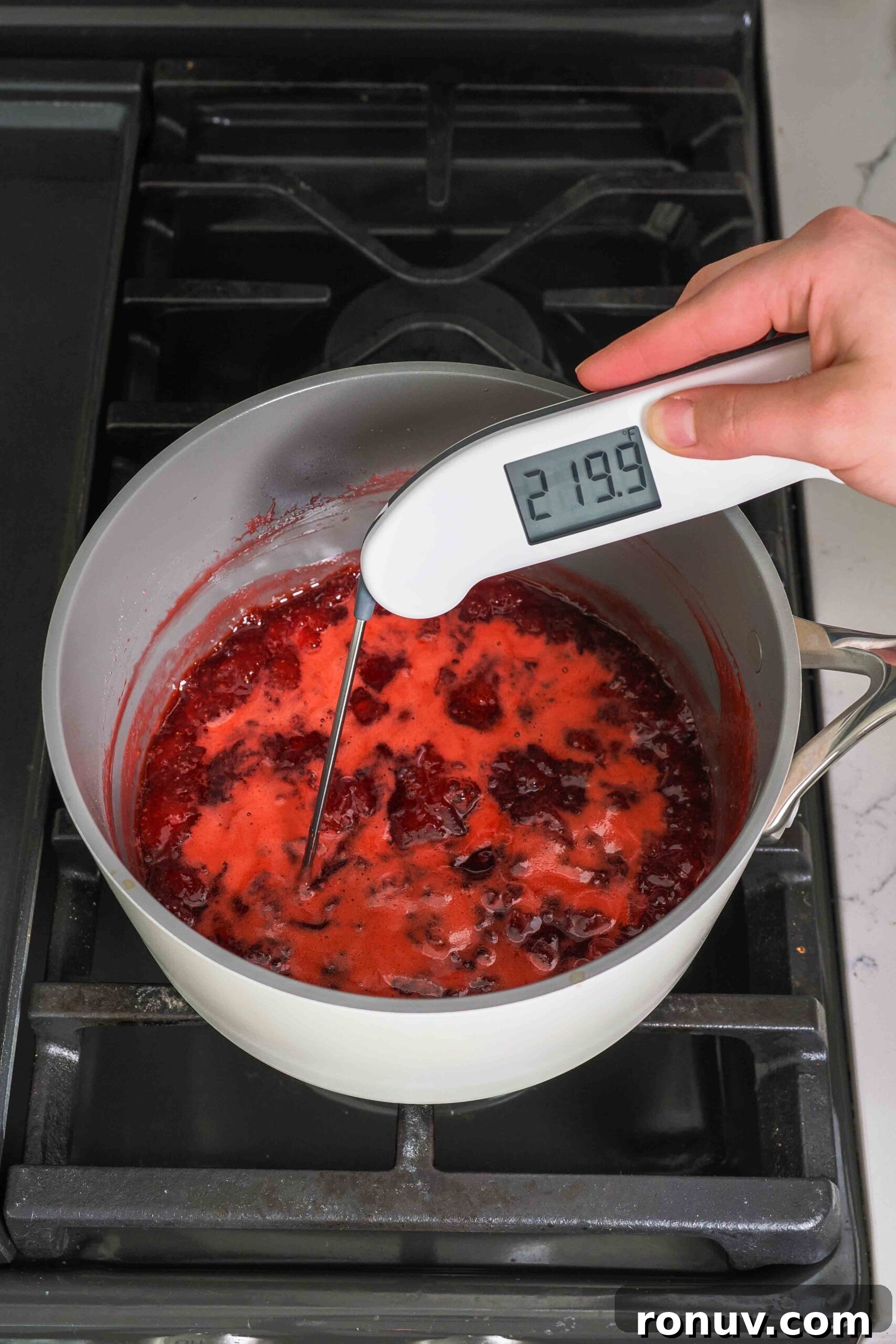 How to Make Small-Batch Strawberry Jam 8 An instant-read thermometer reads 219.9°F over a boiling pot of strawberry jam.