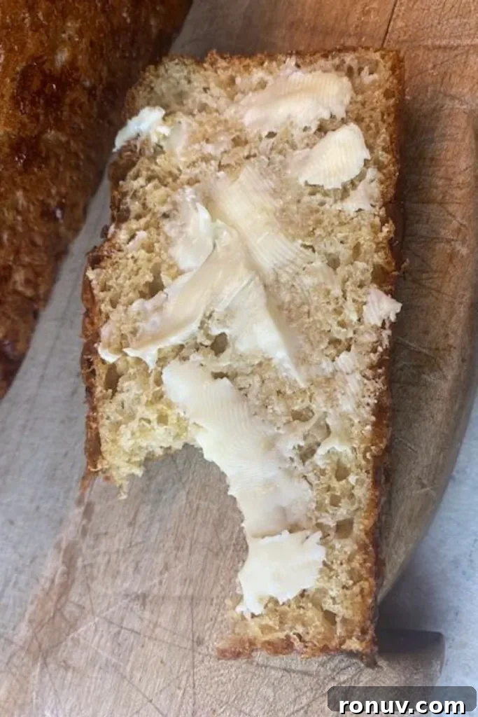 No-Knead Dill Bread Recipe for Crispy, Flavorful Loaves 3 a buttered slice of dilly bread with a bite taken out of it