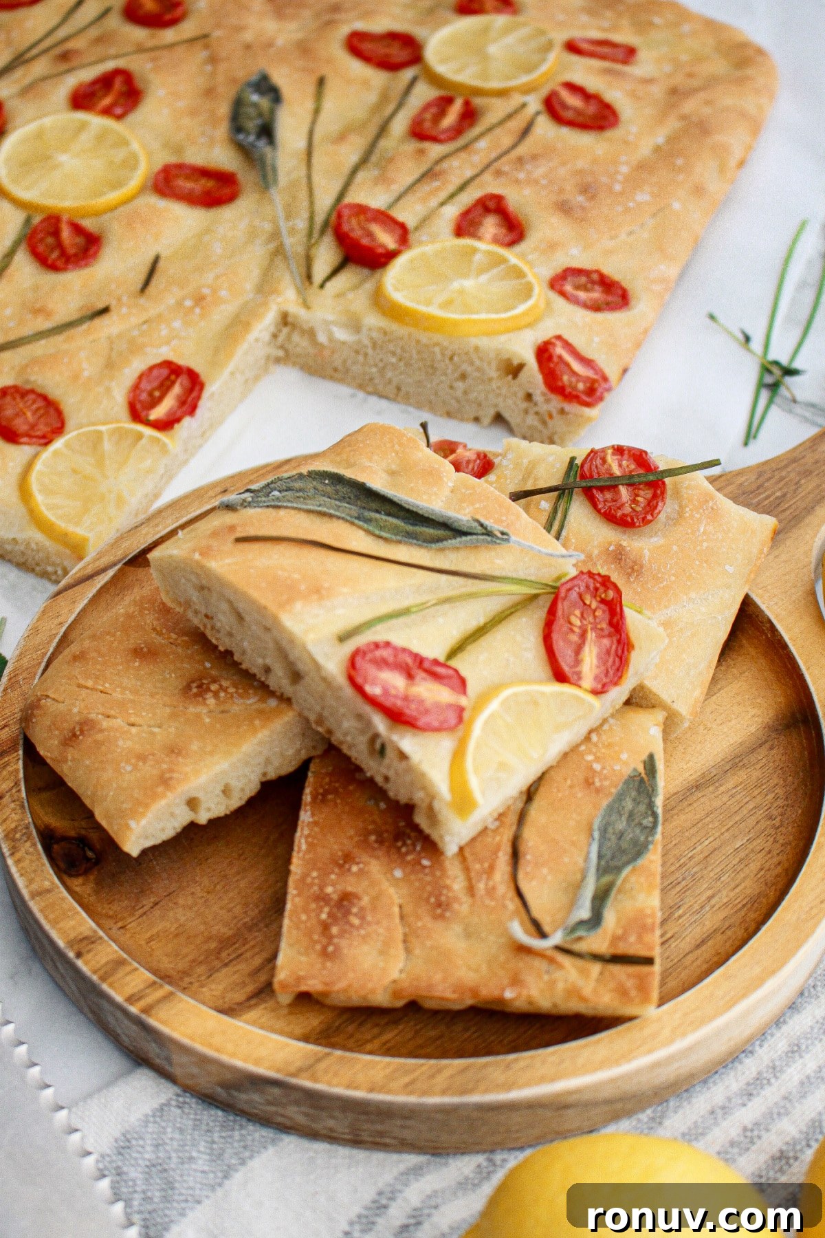 Tomato Focaccia: Classic Italian Bread 2 four pieces of tomato focaccia bread stacked on a wooden cutting board.