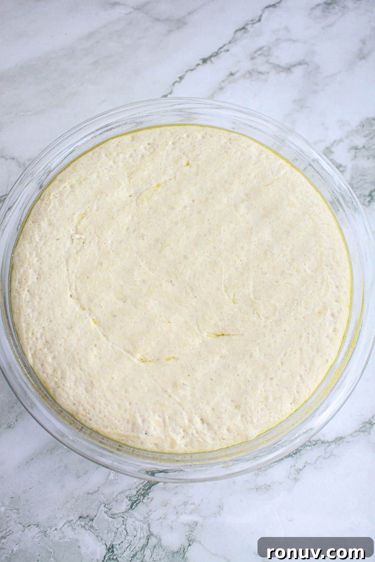 Tomato Focaccia: Classic Italian Bread 6 dough rising in a glass mixing bowl.