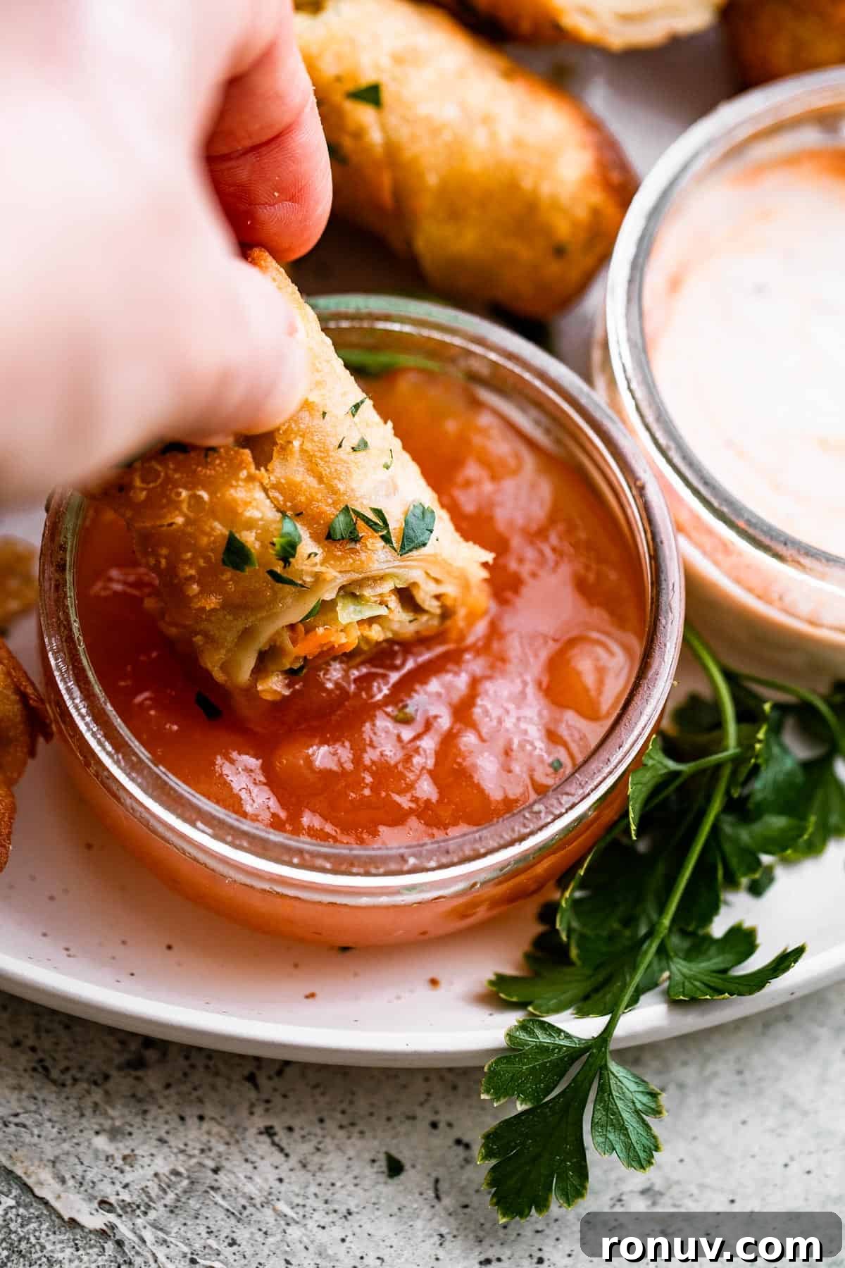 Crispy Golden Vegetable Spring Rolls with Sweet Chili Sauce 3 A small plate of spring rolls and dipping sauce, with one spring roll partially dipped in the sauce.