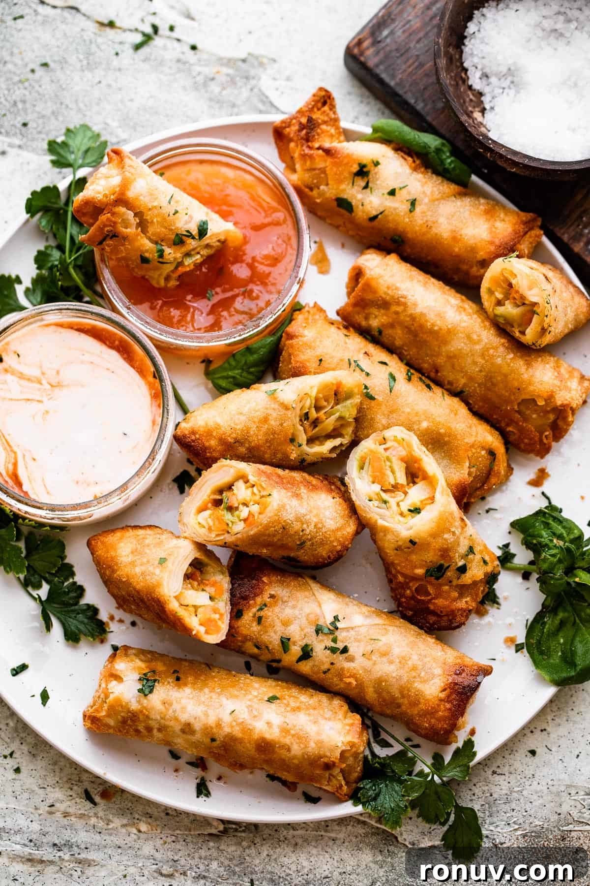 Crispy Golden Vegetable Spring Rolls with Sweet Chili Sauce 8 A plate of spring rolls with dipping sauce.