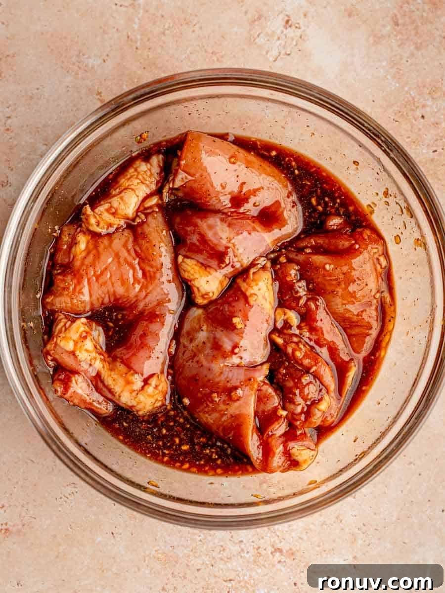 Sticky Honey Garlic Chicken Thighs for Quick Weeknight Dinner 4 Chicken thighs marinating in a bowl.