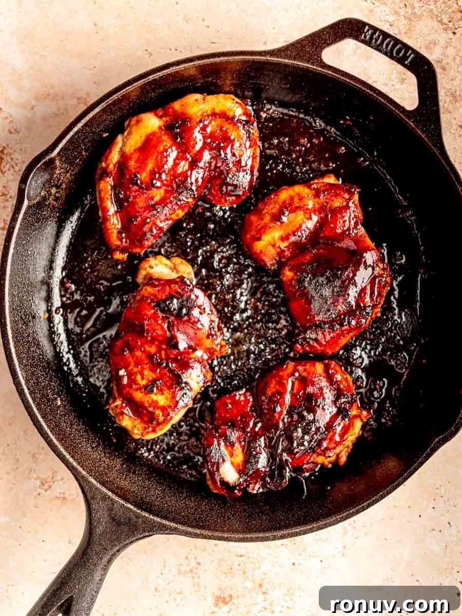 Sticky Honey Garlic Chicken Thighs for Quick Weeknight Dinner 5 Chicken thighs on a cast iron skillet.