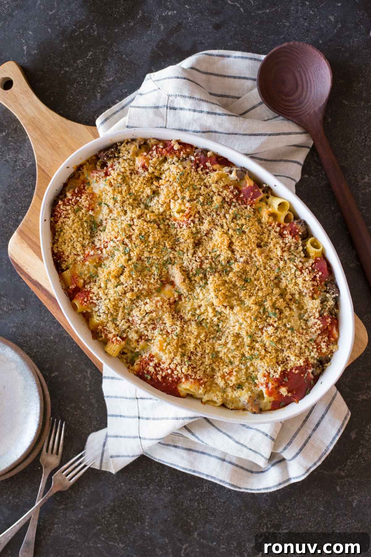Creamy Tomato Alfredo Pasta Bake with Melted Mozzarella 5 Cheesy Tomato Alfredo Pasta Bake in a baking dish, with a serving spoon, plates and forks beside it.